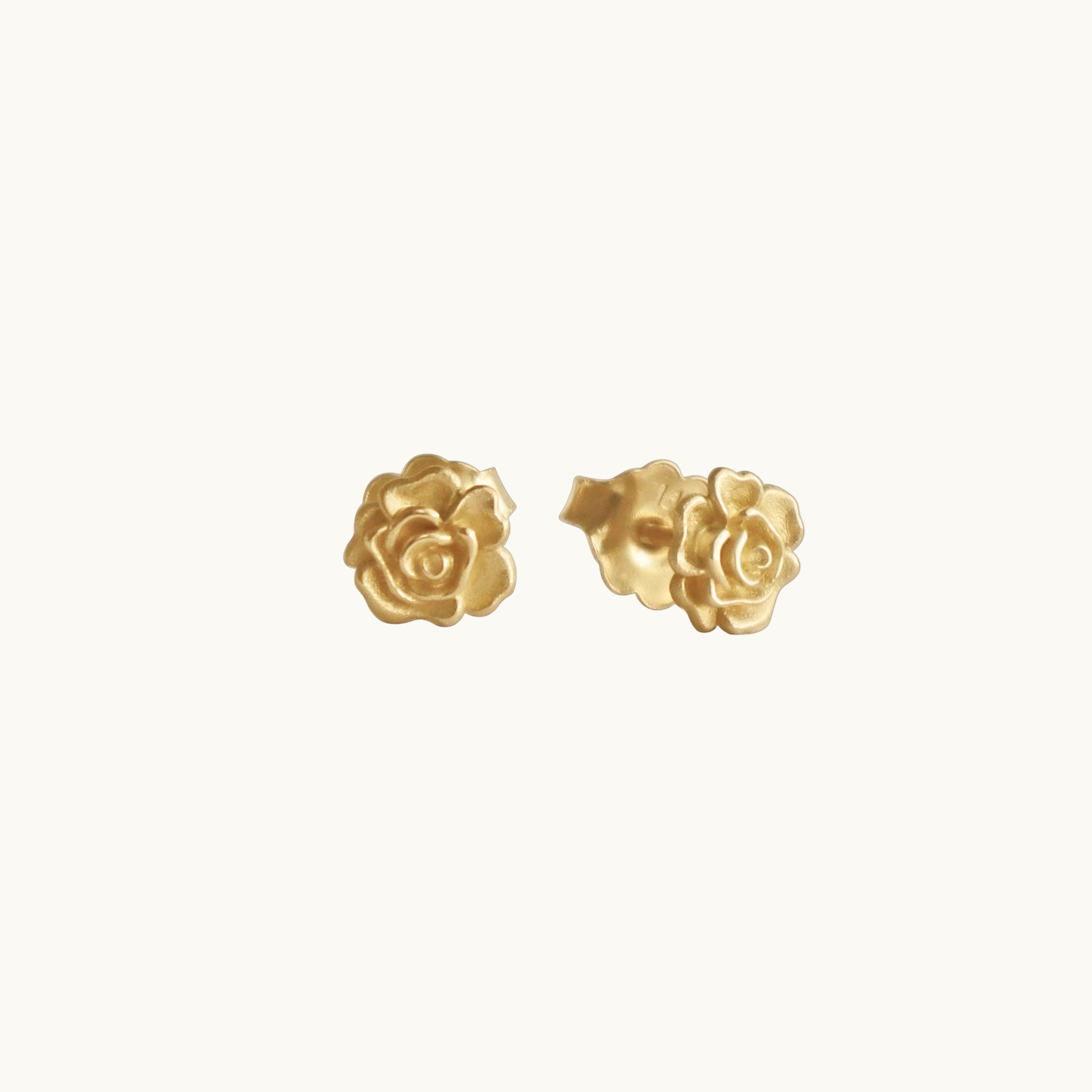 Gold rose-shaped earrings on a white background